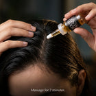 Applying Roots & Ends serum to the scalp at the hairline